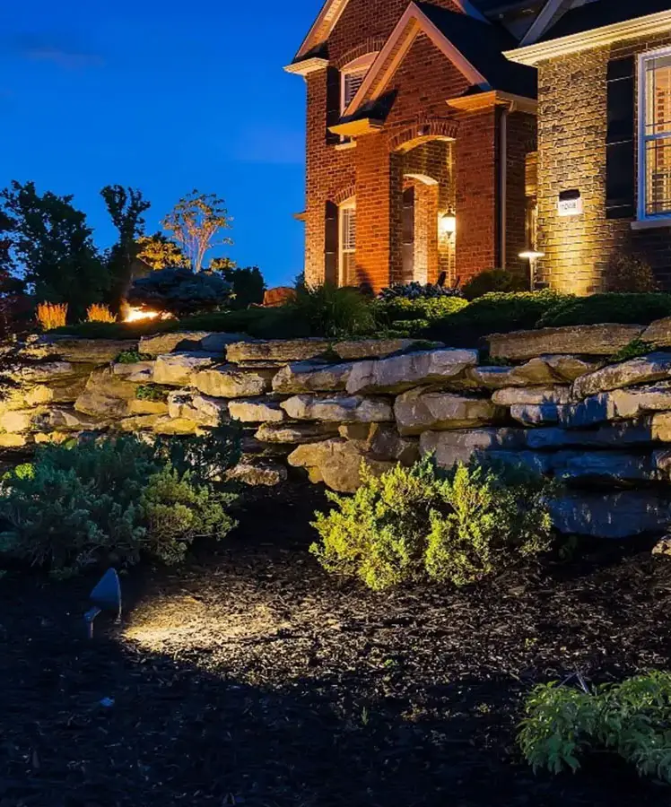 the front yard of a house at dusk showing various types of lighting on display